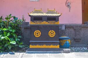 a trash can in the shape of a traditional Chinese house. photo
