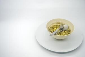 A bowl of instant noodles with rawon flavored soup served isolated on white background with copy space. perfect for menus, and cooking content. photo