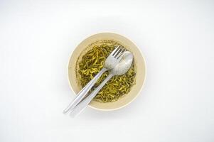 A bowl of instant noodles with rawon flavored soup served isolated on white background with copy space. perfect for menus, and cooking content. photo