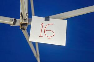 a piece of paper with the number 16 on it clamped on an iron photo