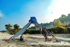 a temporary tarpaulin tent for limestone miners resting in the middle of a limestone quarry photo