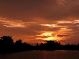 Spectacular sunset over, orange sun rising up over the horizon photo