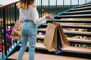 shopping, happiness and people concept - smiling stylish teenage girl with shopping bags. shopping concept photo