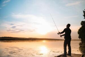 pesca. hilado a puesta de sol. silueta de un pescador. foto