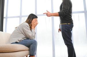 un agitado y trastornado marido gritos y mira a su esposa, un pelea Entre esposos. familia malentendido, pelea foto