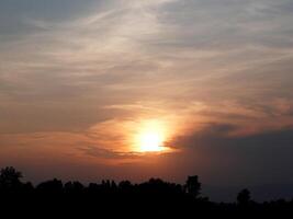 Spectacular sunset over, orange sun rising up over the horizon photo