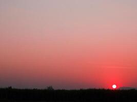 Spectacular sunset over, orange sun rising up over the horizon photo