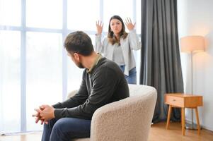 Abusive wife arguing husband, jealous distrustful dominant woman shouting at sad man photo