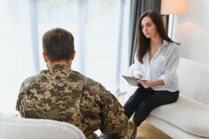 Sad male soldier on appointment with psychologist at office photo