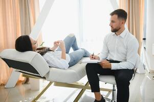 Male doctor and female patient at therapy session photo