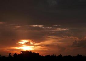 Spectacular sunset over, orange sun rising up over the horizon photo