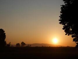 Spectacular sunset over, orange sun rising up over the horizon photo