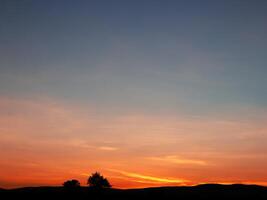 Spectacular sunset over, orange sun rising up over the horizon photo