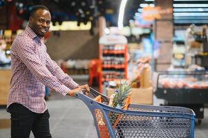 africano americano hombre compras en un supermercado foto