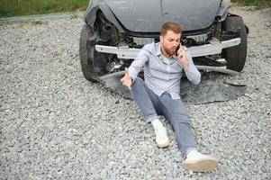 Man calling help after a car crash accident on the road photo