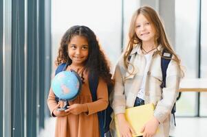 retrato de contento multirracial elemental colegialas. colegio concepto foto