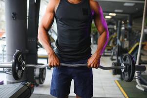 Athletic black guy making weightlifting or powerlifting at modern gym photo