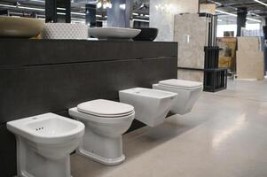 Ceramic toilet bowls of various shapes and sizes in the trading floor of a specialised store photo