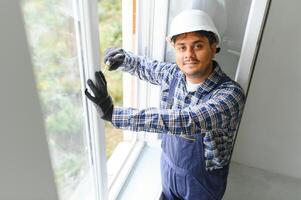 Indian service man installing window with screwdriver photo