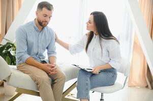 female psychologist making note while patient talking photo