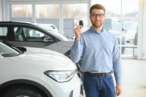 un contento hombre elige un nuevo eléctrico coche a un coche concesión. el concepto de comprando un ecológico coche foto