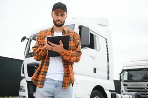 camión conductor comprobación envío lista mientras en pie en estacionamiento lote de distribución almacén foto