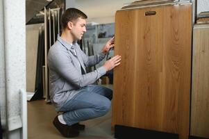 Choosing parquet. Man is in the store of goods for the home photo