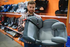 joven masculino con coche asiento para niños en el para niños Tienda foto