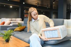 encantador joven mujer elegir ortopédico colchón a comprar foto