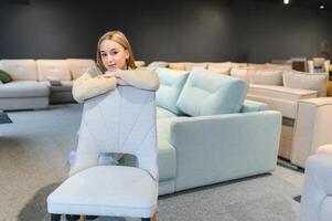 A young woman chooses chairs for the home in a store. photo