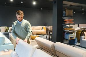 joven hombre comprando sofá en mueble Tienda foto