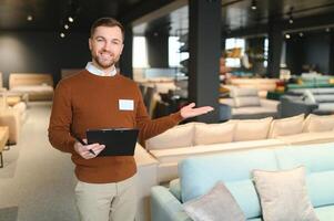 Confident salesman standing in furniture store exhibition center photo