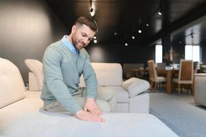 joven hombre comprando sofá en mueble Tienda foto