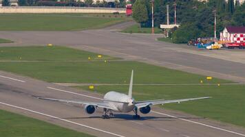 Footage of jet passenger plane flying away. Flight departure. Aircraft takeoff over city and blue sea, rear view video