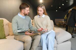 Happy couple choosing furniture in store photo