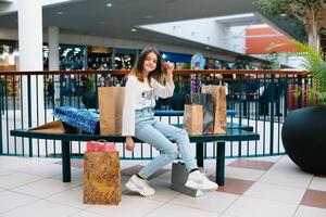 compras, felicidad y personas concepto - sonriente elegante Adolescente niña con compras bolsas. compras concepto. foto