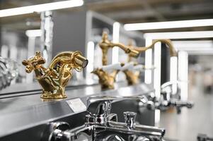 Water taps of different types and shapes on the counter in the store. Retail trade in sanitary ware. Foreground. photo