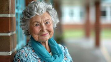 un más viejo mujer con un azul bufanda sonrisas calurosamente foto