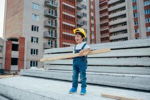 Architect in helmet writing something near new building. little cute boy on the building as an architect. photo