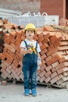 Architect in helmet writing something near new building. little cute boy on the building as an architect photo