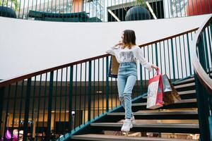 shopping, happiness and people concept - smiling stylish teenage girl with shopping bags. shopping concept. photo