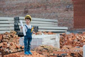 Architect in helmet writing something near new building. little cute boy on the building as an architect photo