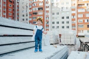 Architect in helmet writing something near new building. little cute boy on the building as an architect photo