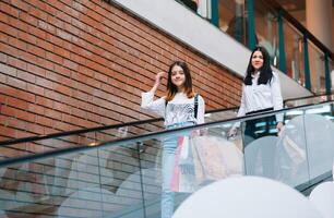 hermosa joven mamá y Adolescente hija son participación compras pantalones y sonriente mientras haciendo compras en centro comercial. familia compras foto