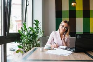 hermosa negocio mujer son sentado a analizar el trabajo plan. negocio niña son estudiando estrategias para desarrollando un márketing plan y aprendizaje a resolver trabajo problemas. foto