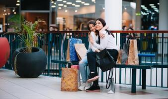 hermosa joven mamá y Adolescente hija son participación compras pantalones y sonriente mientras haciendo compras en centro comercial. familia compras foto