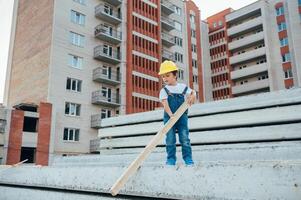 Architect in helmet writing something near new building. little cute boy on the building as an architect. photo