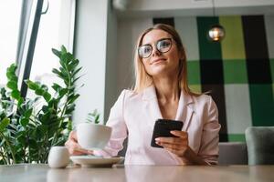 Smiling businesswoman using tablet computer coffee shop photo