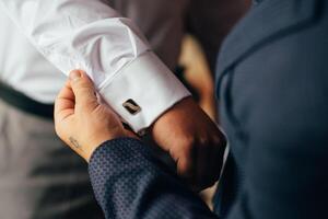 masculino manos en un antecedentes de un blanco camisa, manga camisa con gemelos y relojes, fotografiado de cerca. foto