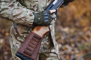 cazador hermoso chico con arma. cazador gastar ocio caza. caza equipo. brutal masculino pasatiempo. hombre observando naturaleza antecedentes. cazador sostener rifle. la seguridad medidas. natural ambiente foto